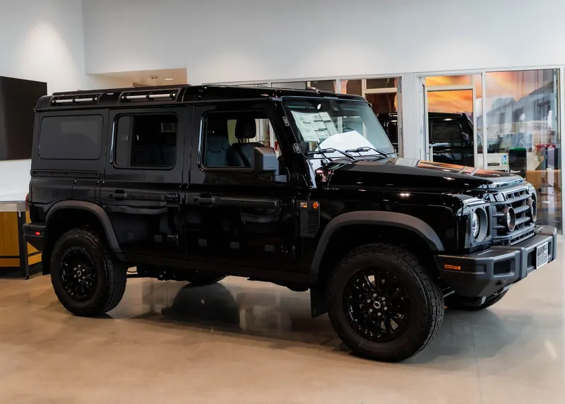 A black Grenadier parked on a polished showroom floor