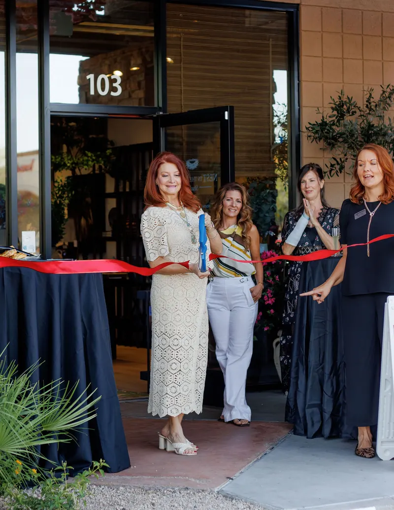 A shop owner and guests cut the ribbon at the door of Nest in the Desert