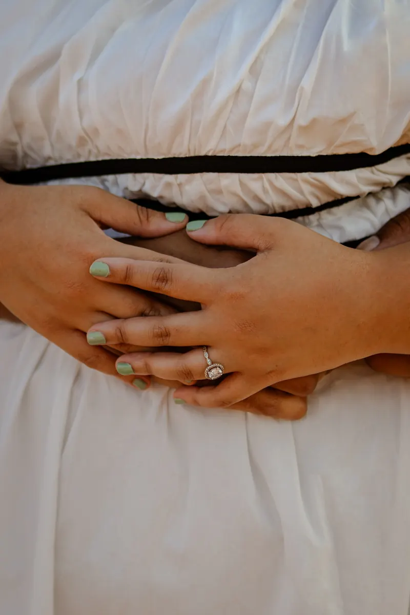 Close up of a couple's hands showing her engagement ring